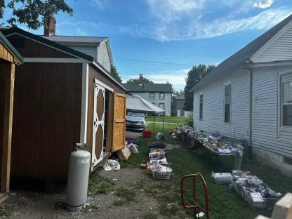 Junk overflowing from sheds and onto the lawn.