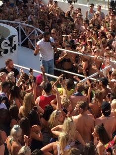 A man performing on stage for a large crowd of people.