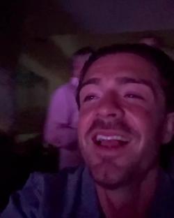 Jack Grealish smiling at a Rod Stewart concert.
