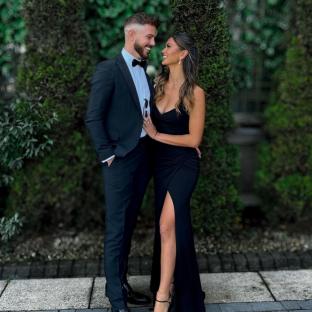 Couple in formal wear smiling at each other.