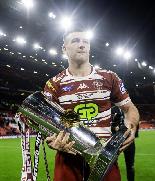 Rugby player holding the Grand Final trophy.