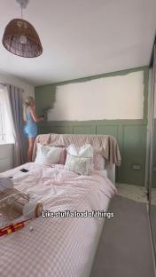 Woman painting bedroom wall sage green.