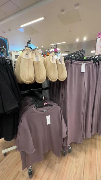 A display of an autumn co-ord in Primark, featuring cream-colored slippers and a lilac t-shirt and sweatpants.