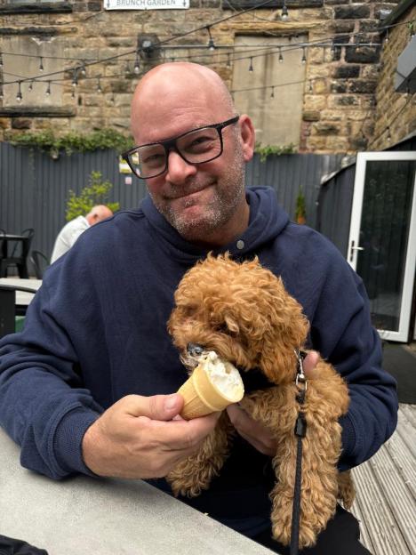 John Mitchell and a puppy sharing an ice cream cone.