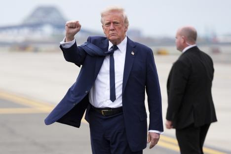 President Trump arriving at an airport, raising his fist.