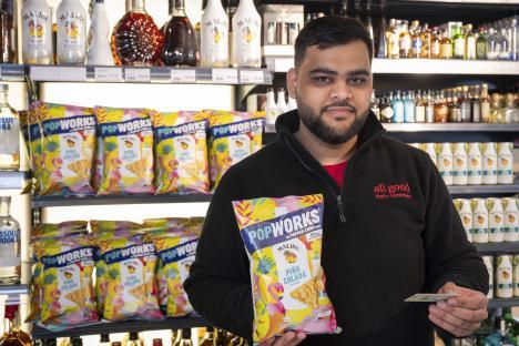Man in a liquor store holding a bag of Malibu Piña Colada PopWorks.