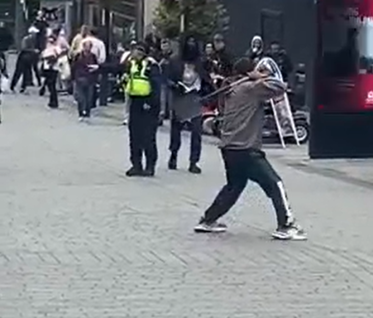 Shocking moment man wielding SPADE faces off with cops before being rugby tackled to floor by have-a-go hero