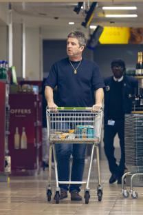 Noel Gallagher grocery shopping with a shopping cart.