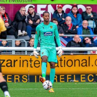 Soccer goalkeeper in teal uniform controlling the ball.