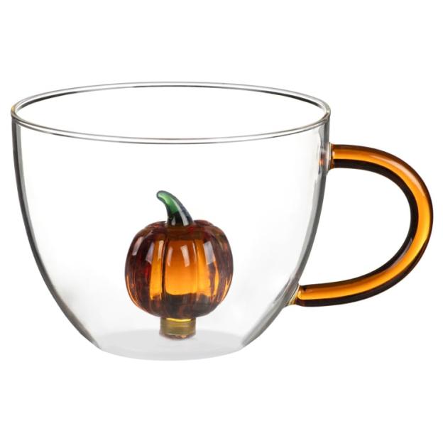 Glass mug with a small pumpkin decoration inside.