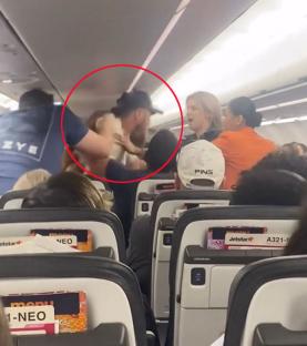 Video still of two passengers fighting on an airplane.