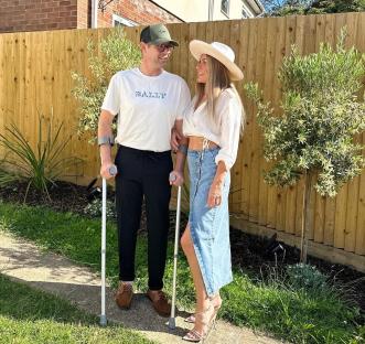 A man on crutches with his arm around a woman.