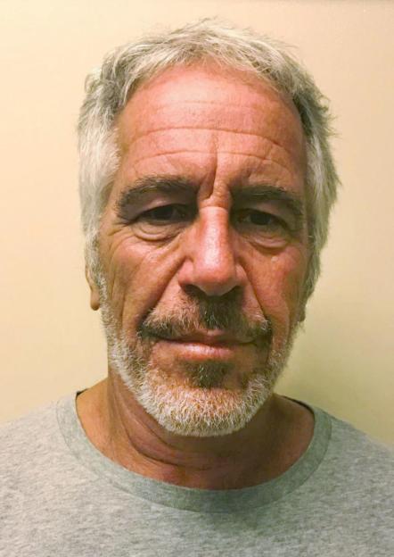 Mugshot of Jeffrey Epstein, a white man with gray hair and beard, wearing a gray t-shirt.