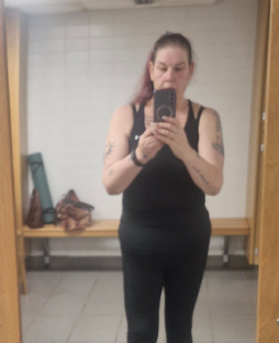 Woman taking a selfie in a gym locker room.