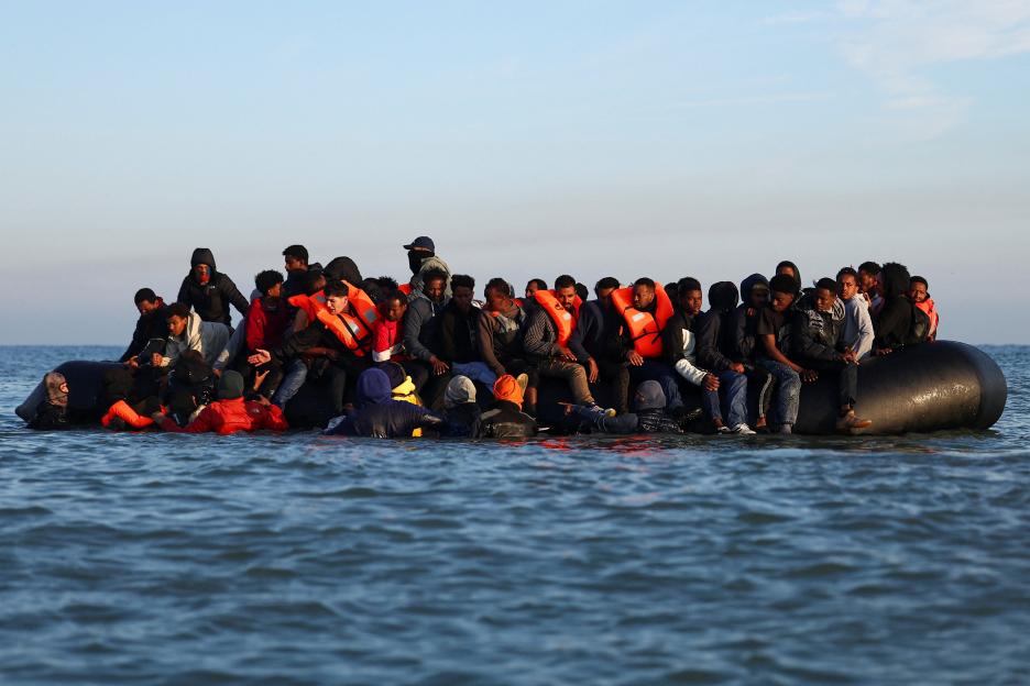 A group of migrants in an inflatable dinghy departing from the beach of Petit-Fort-Philippe.