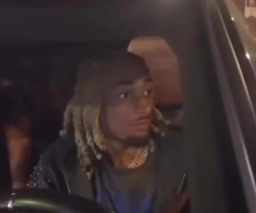 Man in car with blonde dreadlocks.