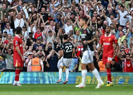 Mikel Merino of Arsenal celebrates scoring a goal, surrounded by cheering fans.