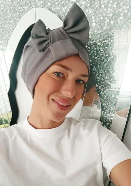 Chelsea Davies, a woman with ovarian cancer, wearing a gray head covering.