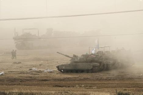 Military tanks in a dusty field.