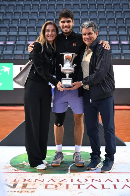 ROME, ITALY - MAY 18: Carlos Alcaraz of Spain poses for a photo with the trophy with his mother, Virginia Garfia Escandon, and father, Carlos Alcaraz Gonzalez, following victory against Jannik Sinner of Italy in the Men's Singles Final match on Day Fourteen of the Internazionali BNL D'Italia 2025 at Foro Italico on May 18, 2025 in Rome, Italy. (Photo by Tullio Puglia/Getty Images)