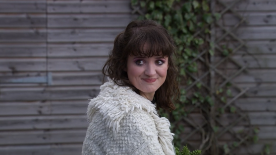 Woman smiling and looking over her shoulder.