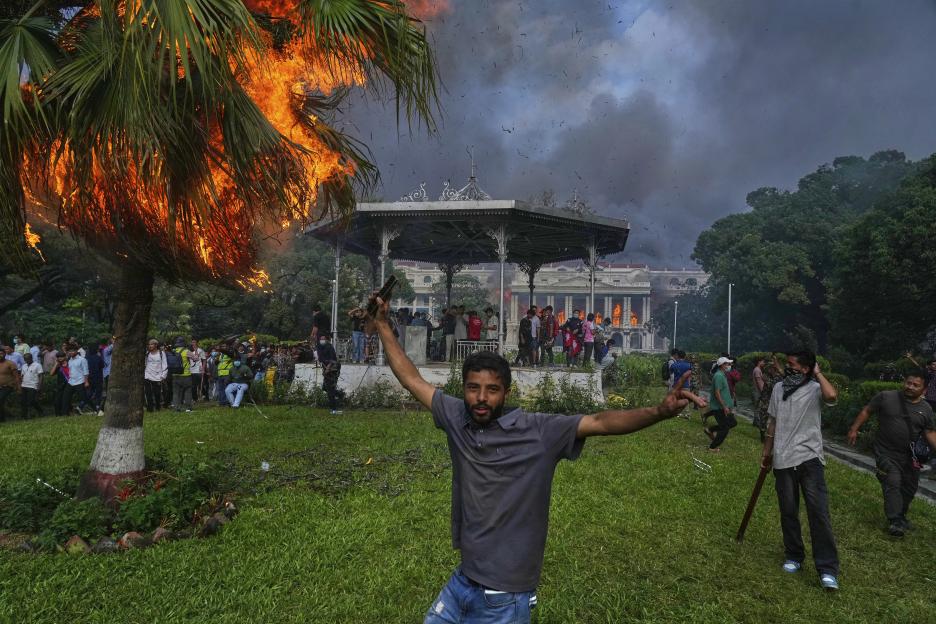 Protester celebrating near burning Singha Durbar in Kathmandu, Nepal.