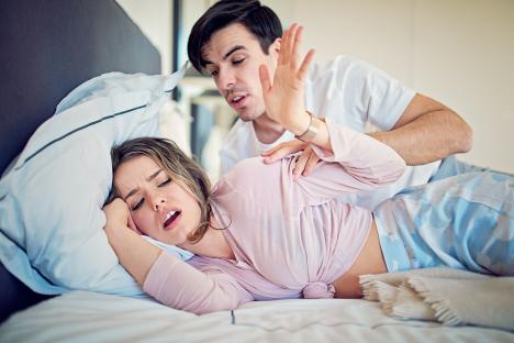 A man rejecting a woman's sexual advances in bed.
