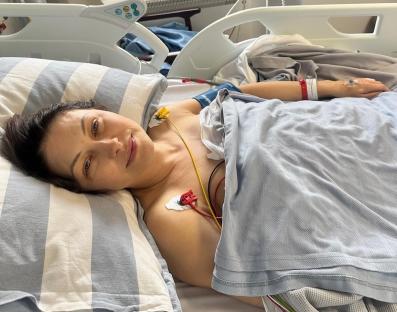 Woman in hospital bed recovering from heart surgery.
