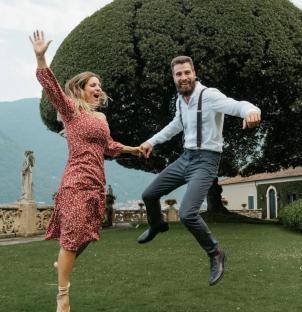 Couple joyfully jumping in a garden.