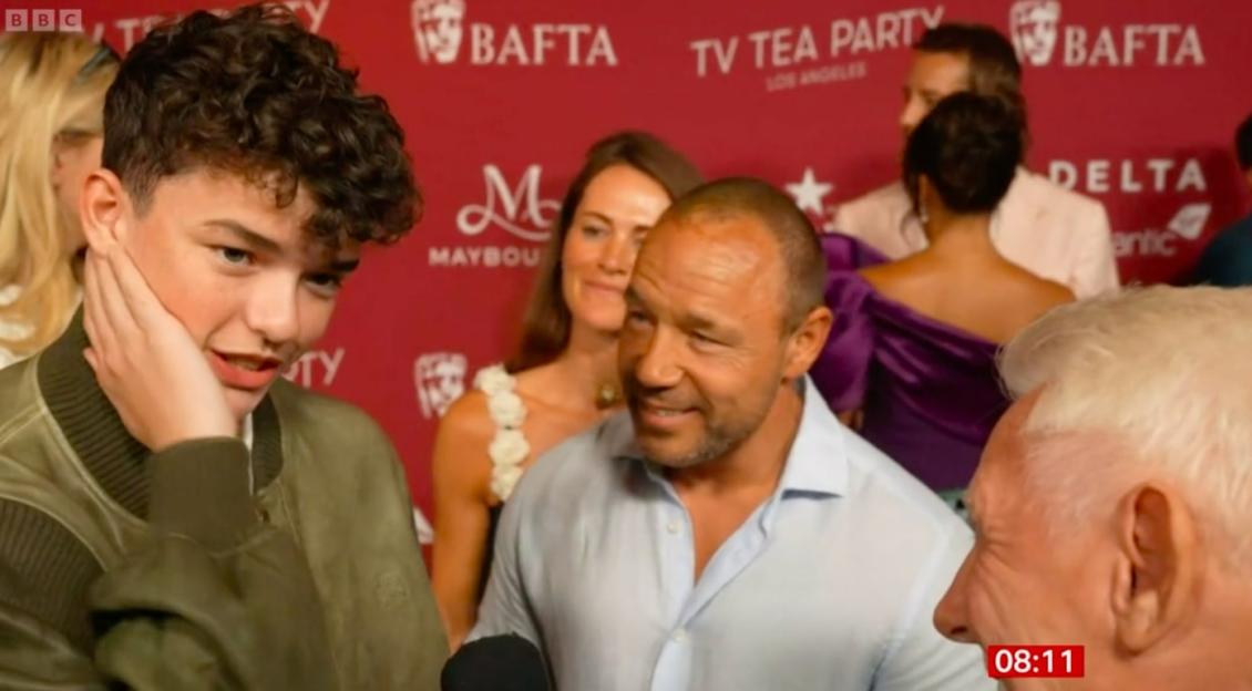 A young man being interviewed at an awards ceremony.