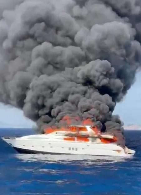 A yacht on fire at sea.