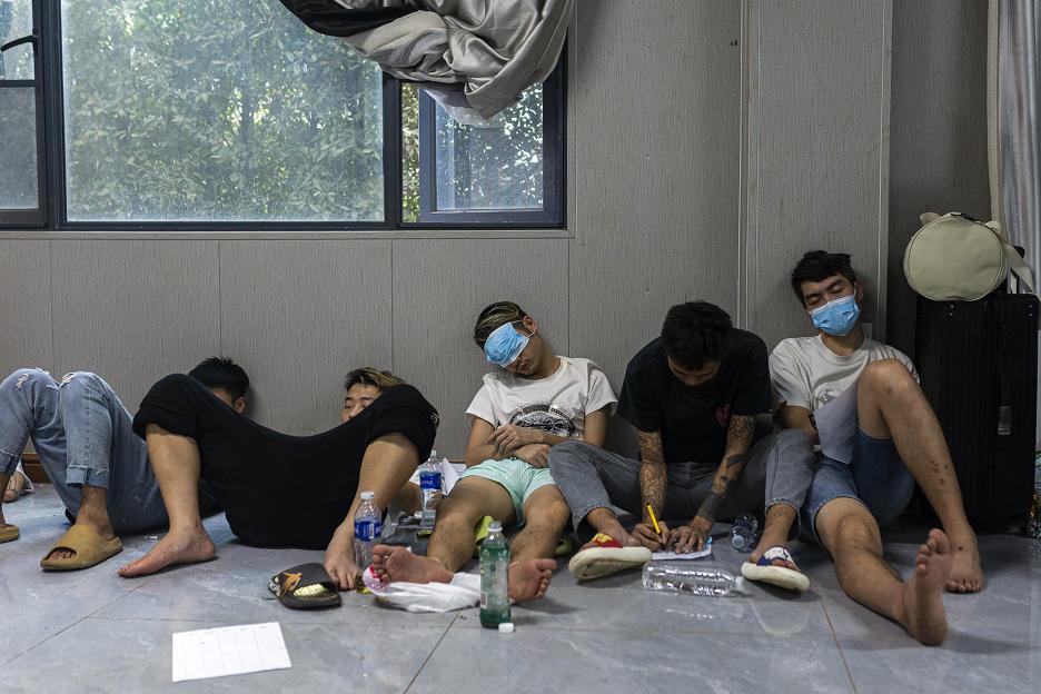 Workers and victims of an alleged scam center resting during a crackdown operation.