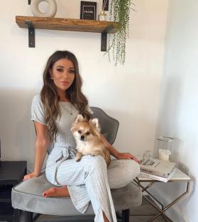 Woman sitting in a chair with her small dog.