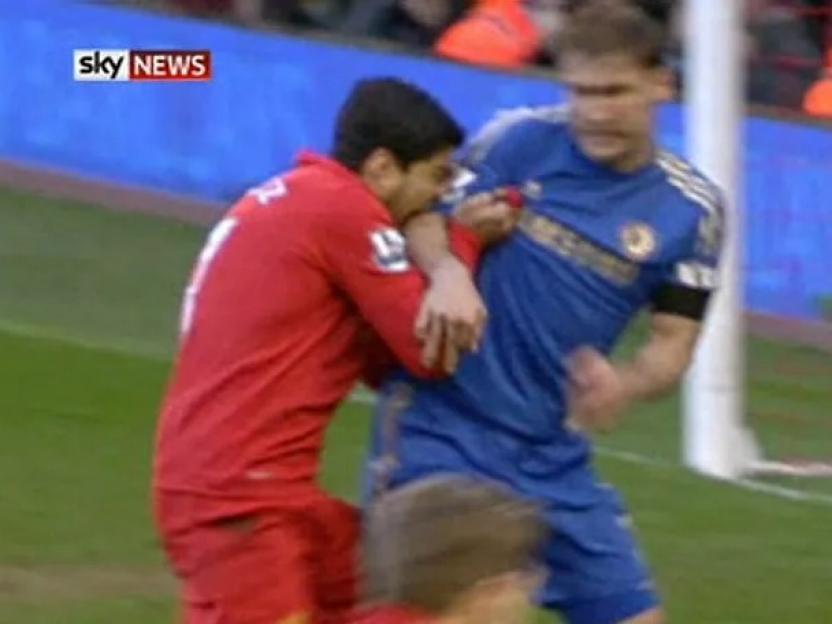 Suarez biting Ivanovic during a soccer match.