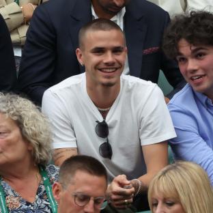 Romeo Beckham watching a Wimbledon tennis match.