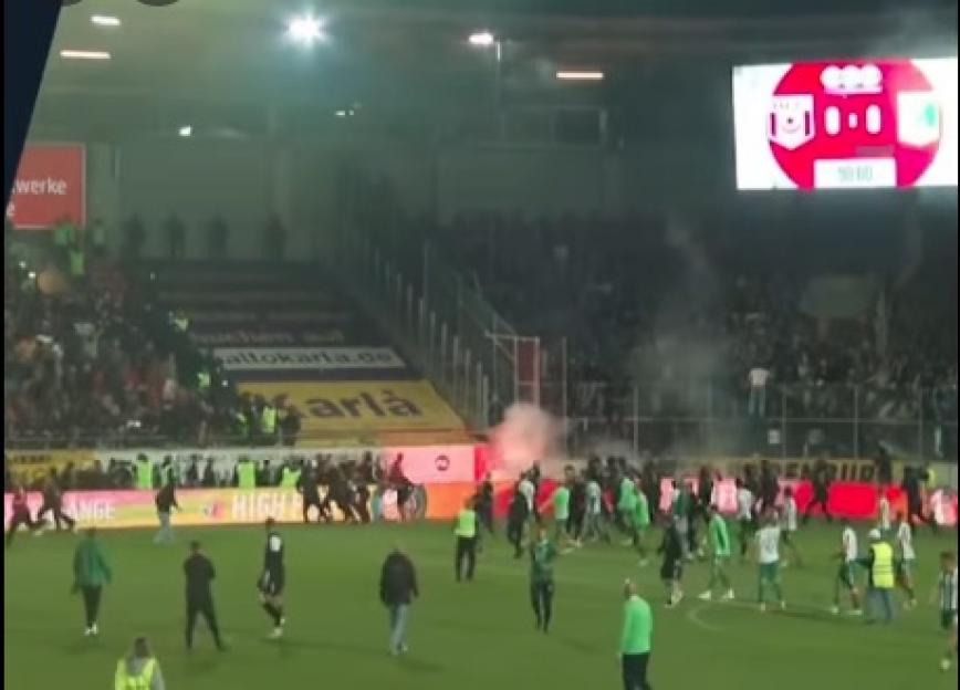 Soccer game interrupted by flares thrown from the stands.