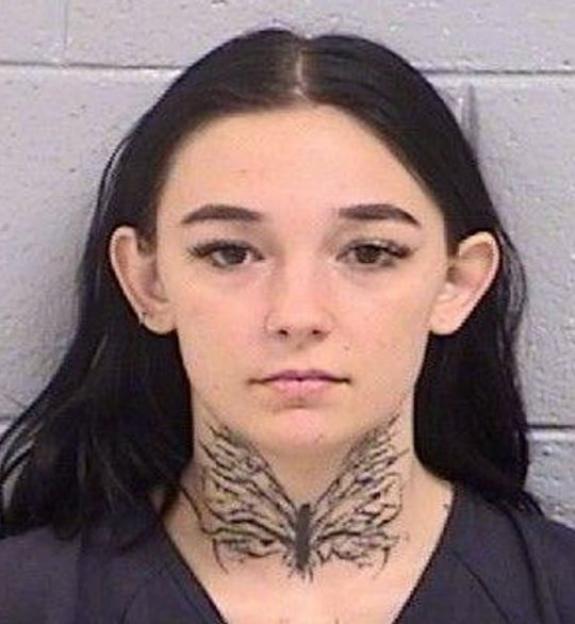 Mugshot of Kalyn Kenworthy, a woman with a history of street racing and speeding violations, with black hair and a butterfly tattoo on her throat.