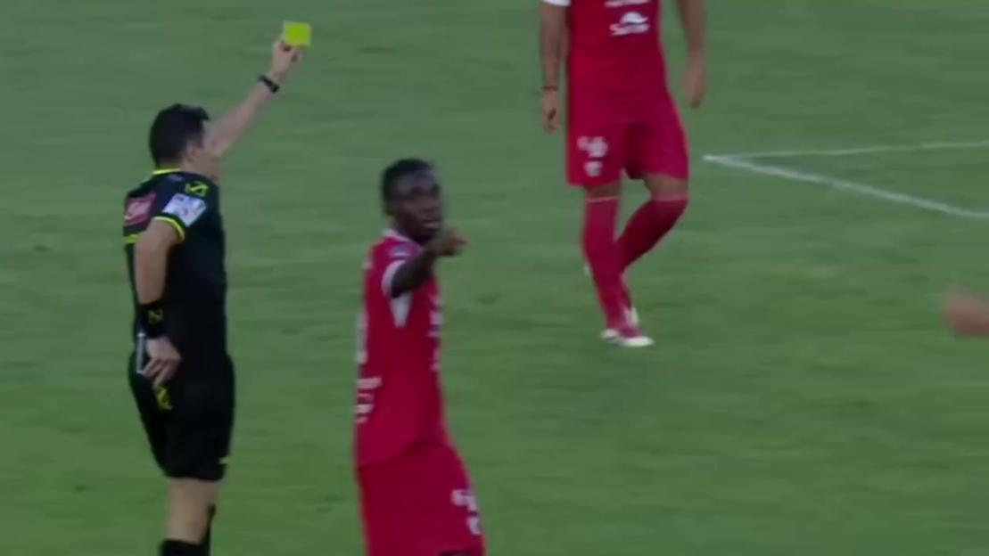 Soccer referee showing a yellow card to a player.