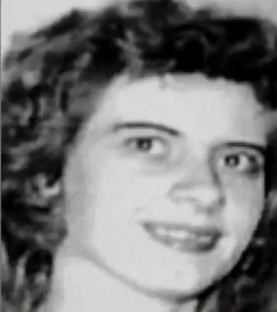 Black and white photo of a smiling woman with curly hair.
