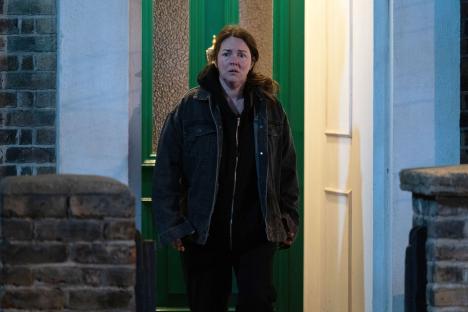 Stacey Slater from EastEnders standing outside a door.