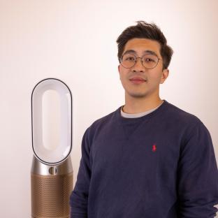 Man standing next to air purifier.