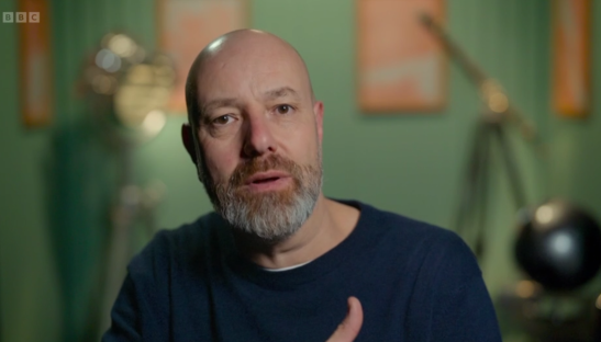Screenshot of a man speaking.