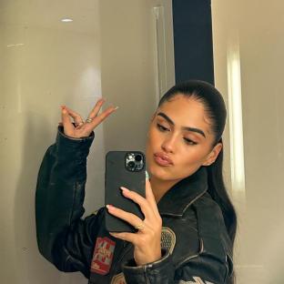 Woman in leather jacket taking a selfie.