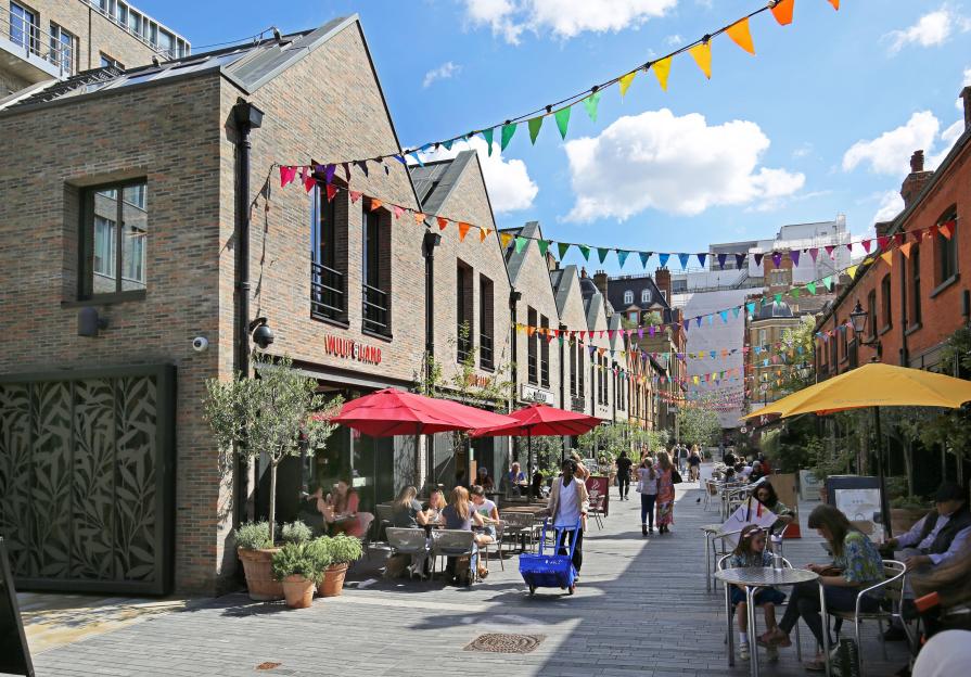 Pedestrianized street in Chelsea, London, with cafes and shops.