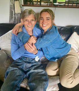 Woman hugging her father on a couch.