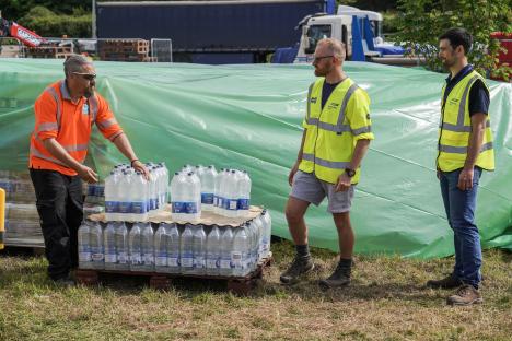Water distribution point with workers and bottled water.
