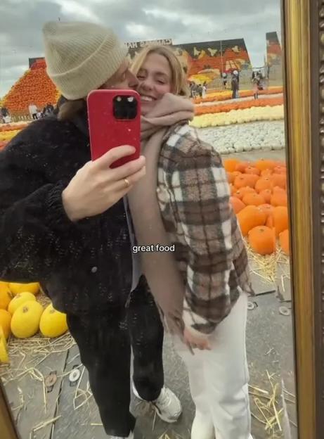 Reflection of a couple taking a selfie in a mirror at a pumpkin patch.