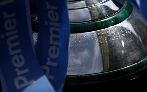 Engraved Premier League trophy with winning teams listed.