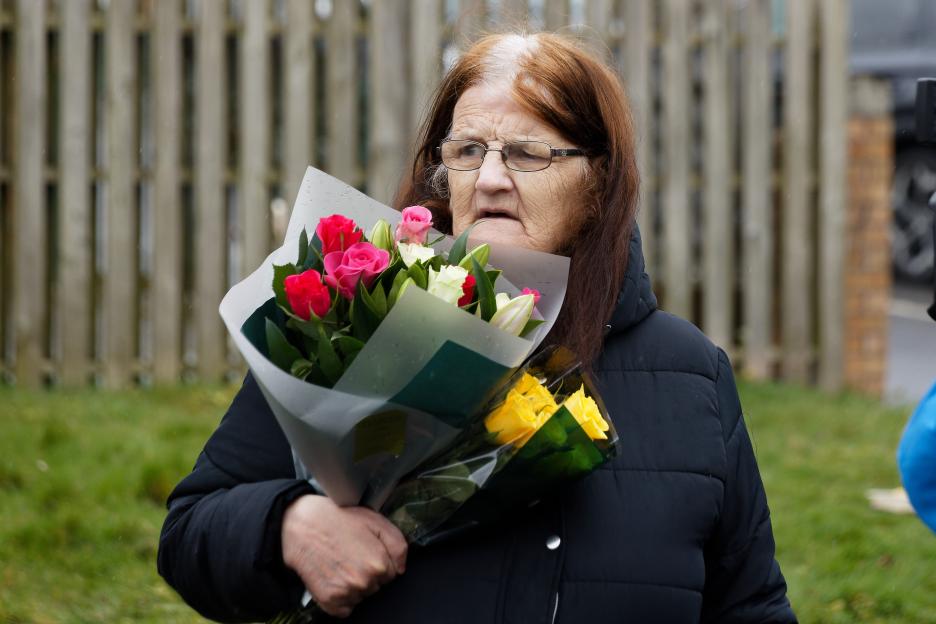 Local resident taking flowers to the scene of a shooting in Green Park, Talbot Green, Wales.