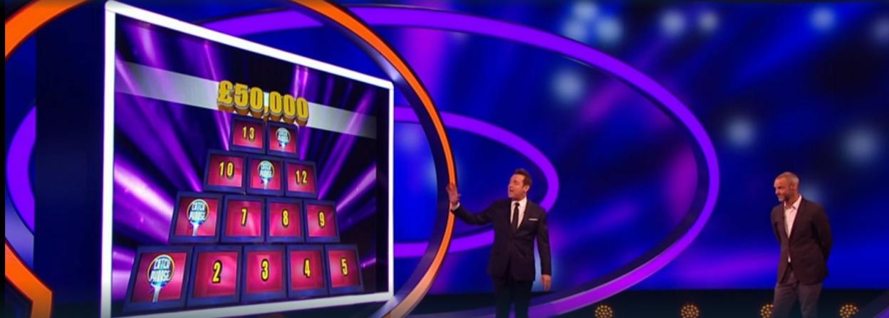 Catchphrase game show scene with two hosts and a pyramid of numbered squares.